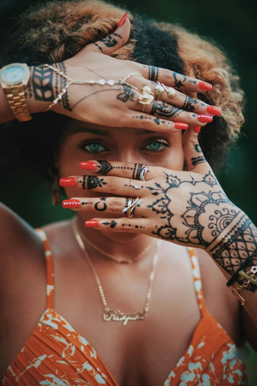 a beautiful woman covered in hendix and wearing rings