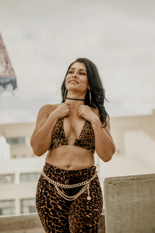 a woman standing with her belly exposed wearing leopard print clothing