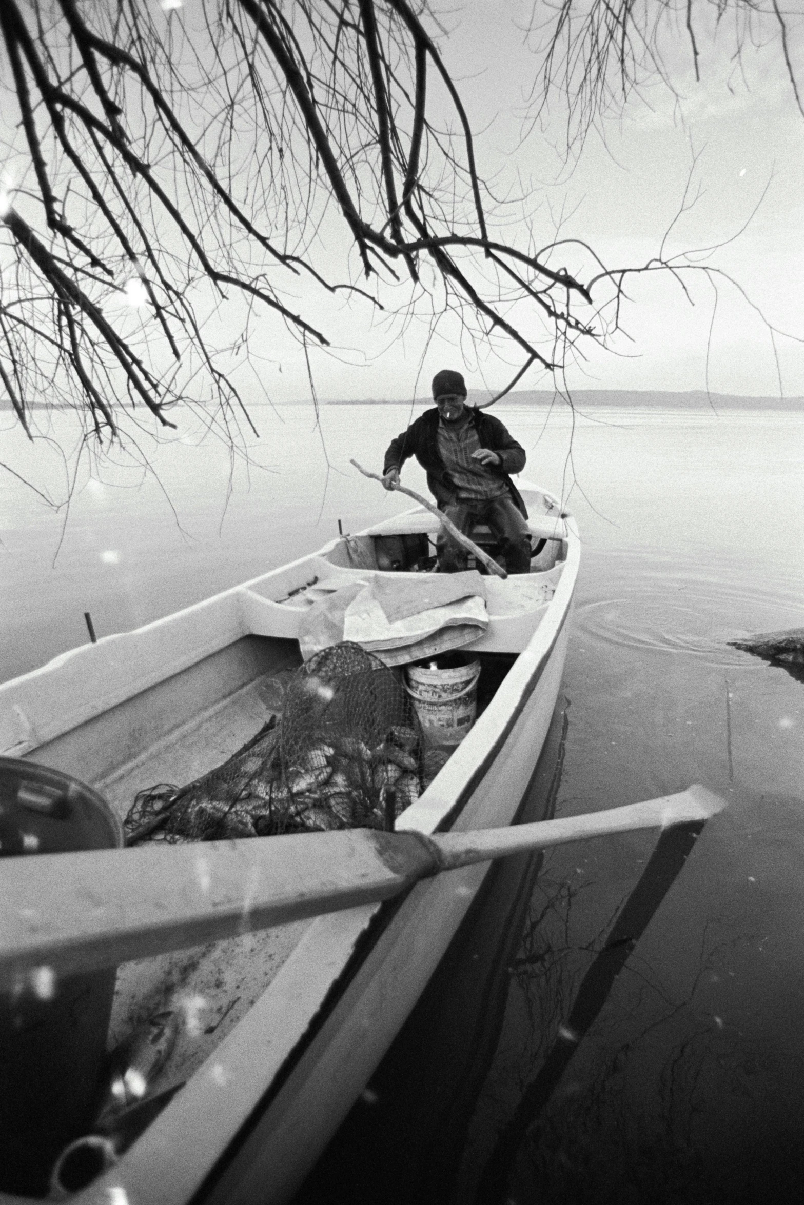 a man sits in a boat with his fishing gear