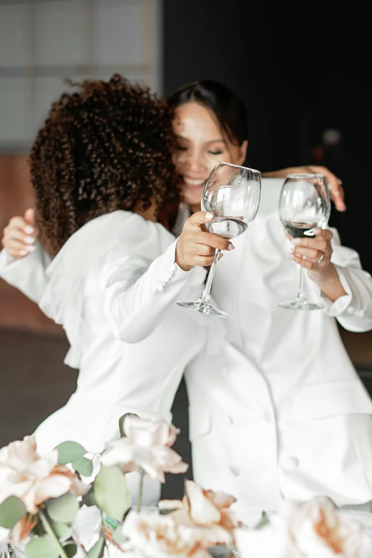 two woman that are sitting down having wine