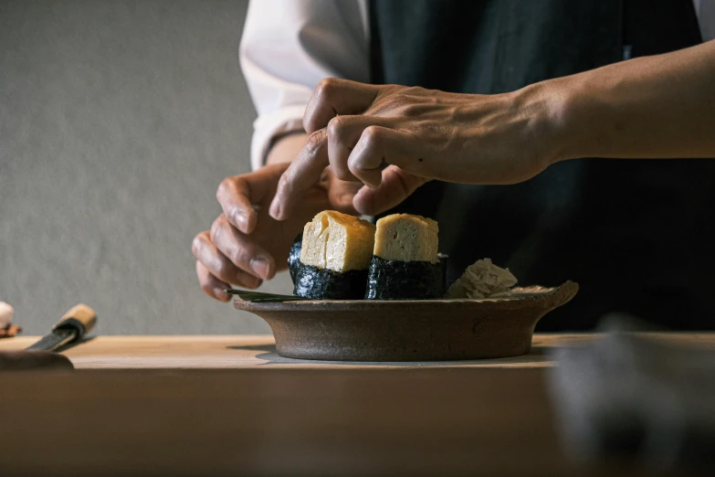 two people are holding hands over a sushi dish