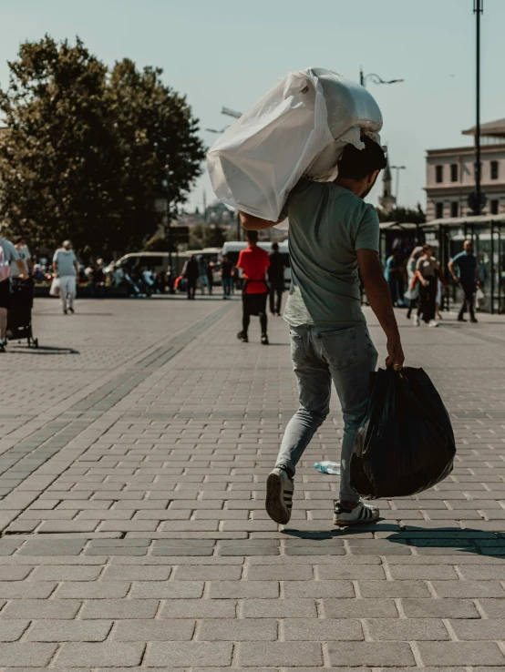 a man carries a huge amount of white covering over his head