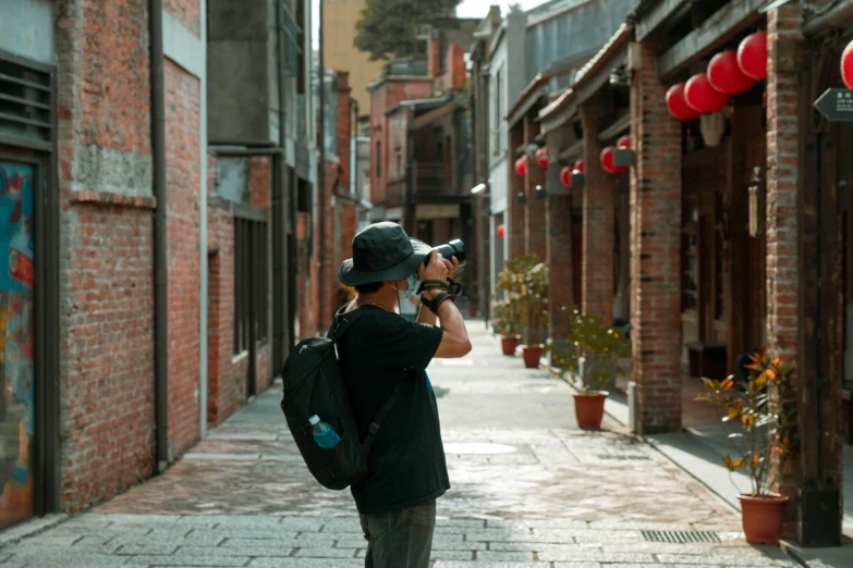 a man walking down a street next to tall buildings