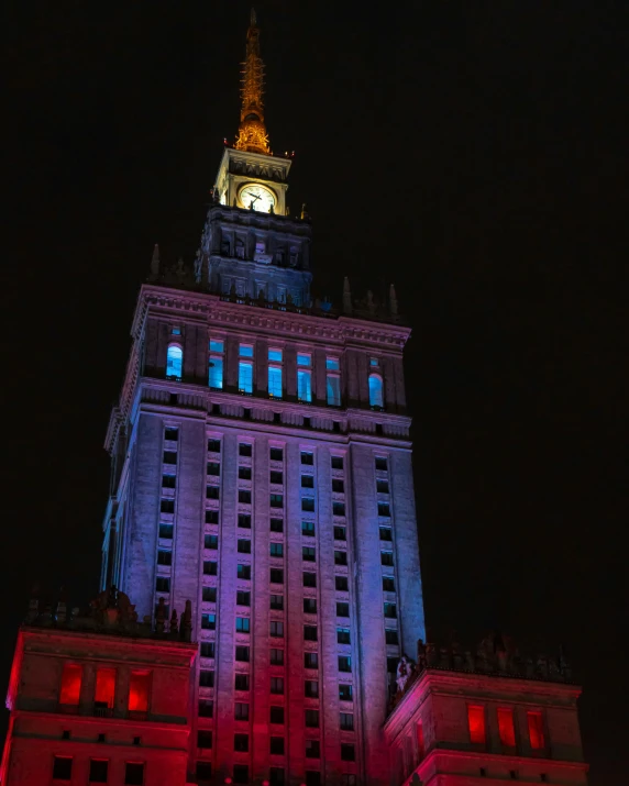 the clock tower lights up the sky at night