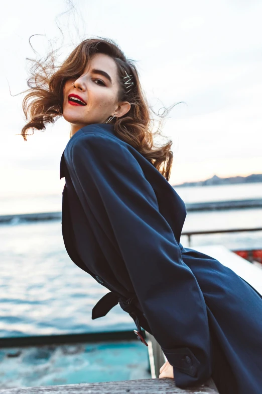 a woman is sitting on the dock looking at the camera