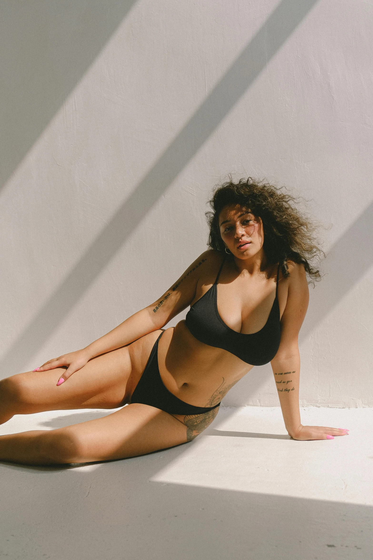 a woman is laying on the floor posing in a bikini