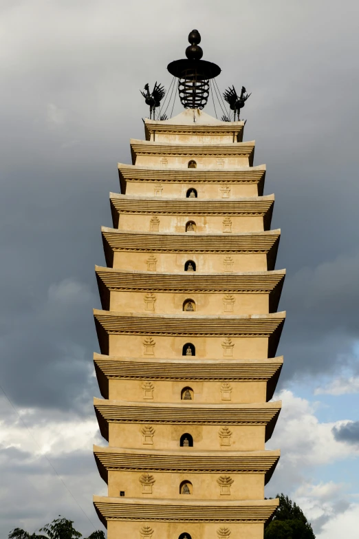 a tall statue with sculptures on it is in a park