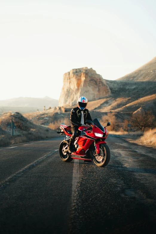 two people sitting on a motorcycle stopped on the road