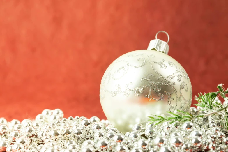 a silver ball sits on a pile of beads