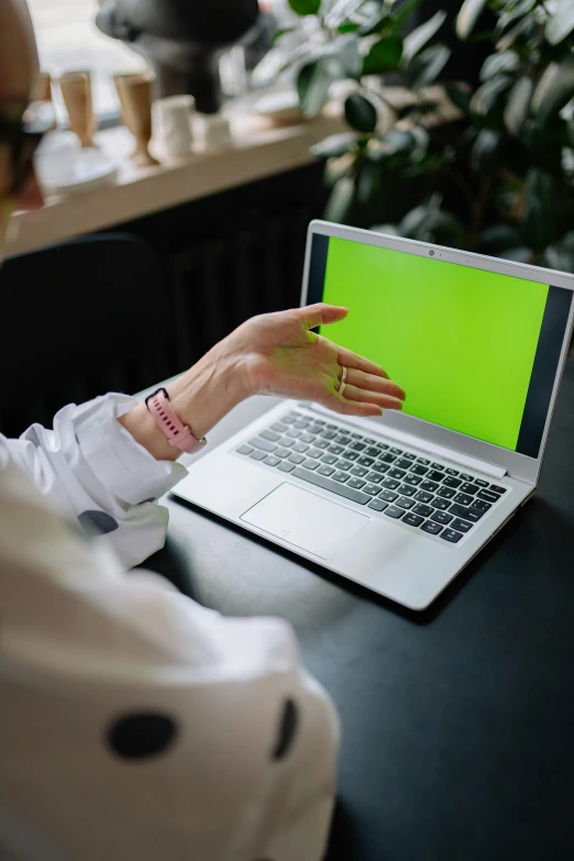 a woman sitting at a table with a laptop on her lap