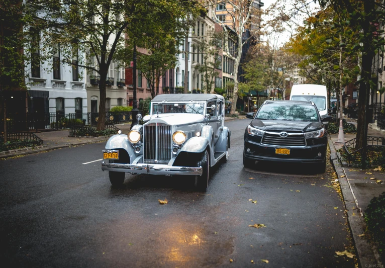 a white and a black car parked in front of a black truck