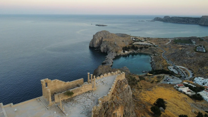 a castle sits next to a rocky cliff