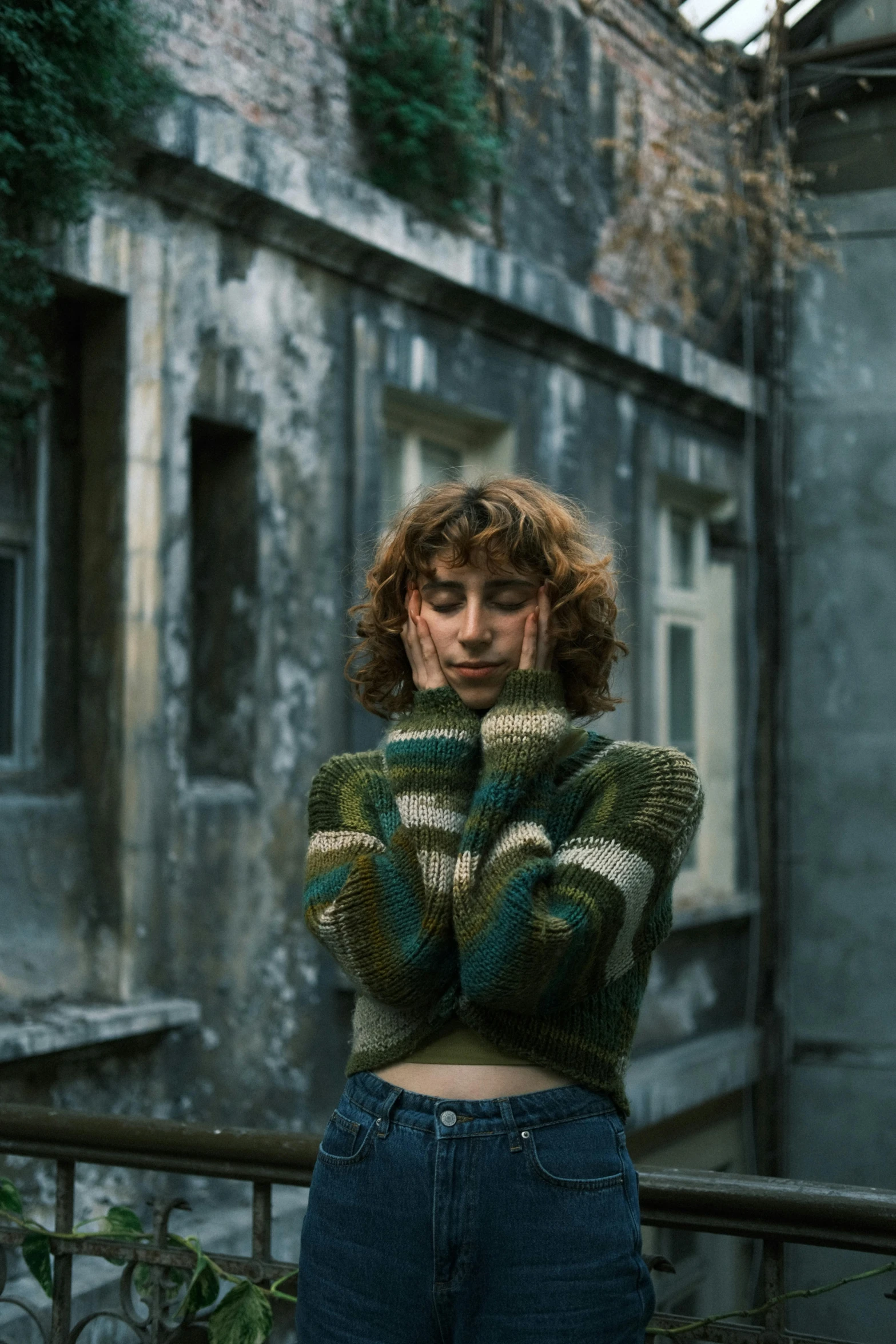 a young woman posing on an outside ledge