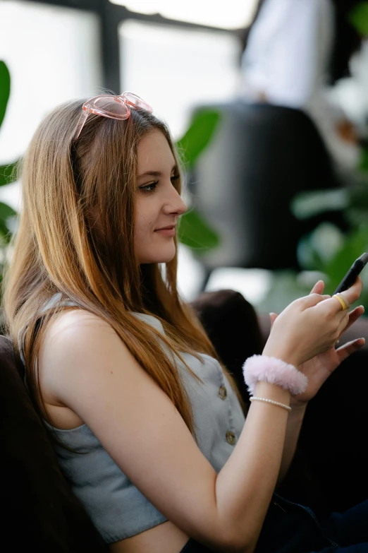 a young woman holding a smart phone in her hands