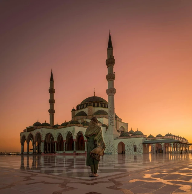 the sun is setting and there is an image of the person at sunrise by a mosque