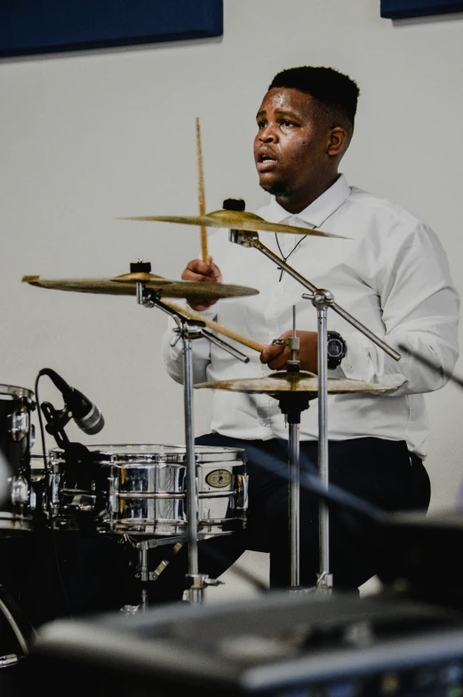 drummer playing drums in front of microphones