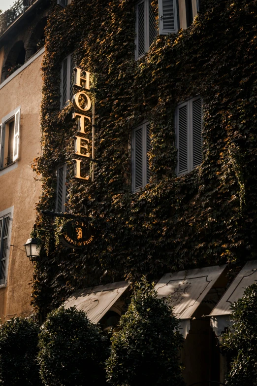 the sign on the side of an old brick building covered in ivy