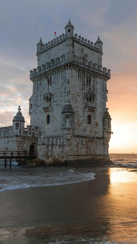 a very tall castle sits near the ocean