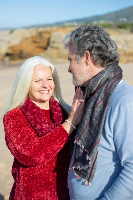 a woman putting a ring on the ear of an older man