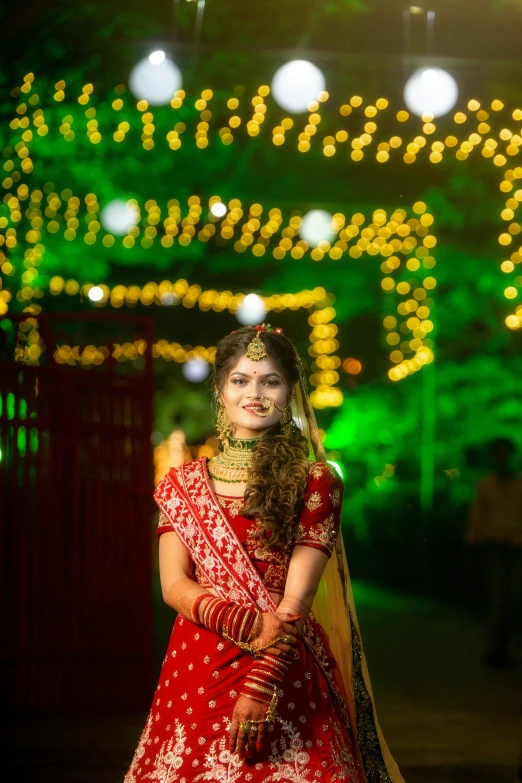 a woman in a red wedding gown standing under lights