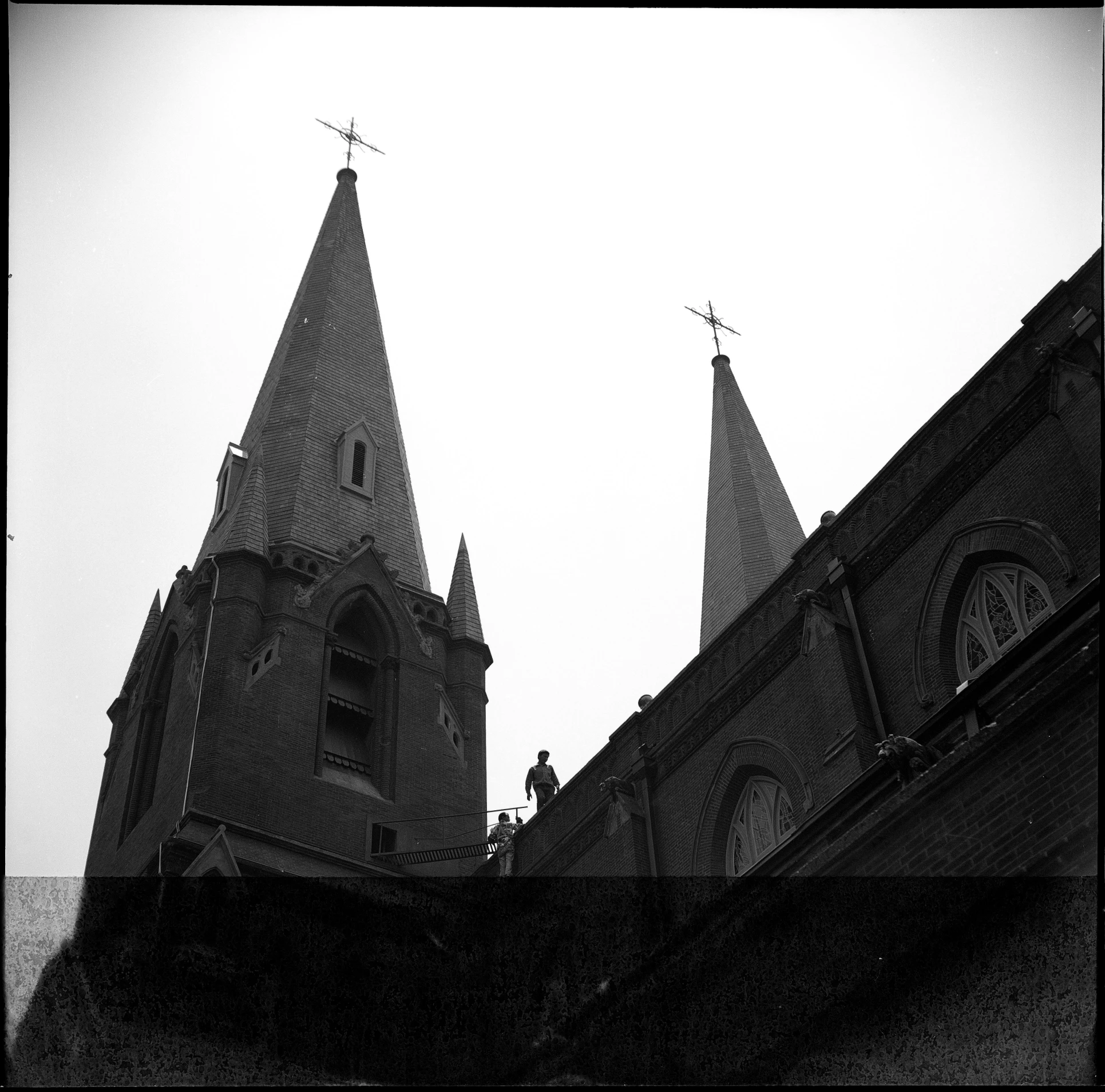 two tall towers are pictured against a gray sky