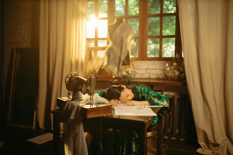 a person laying on their stomach at a desk with a laptop and computer screen