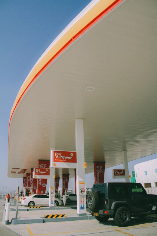 a gas station with a truck driving by it