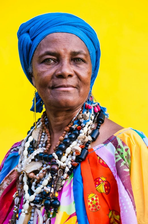 a woman wearing a blue head scarf with beads around her neck