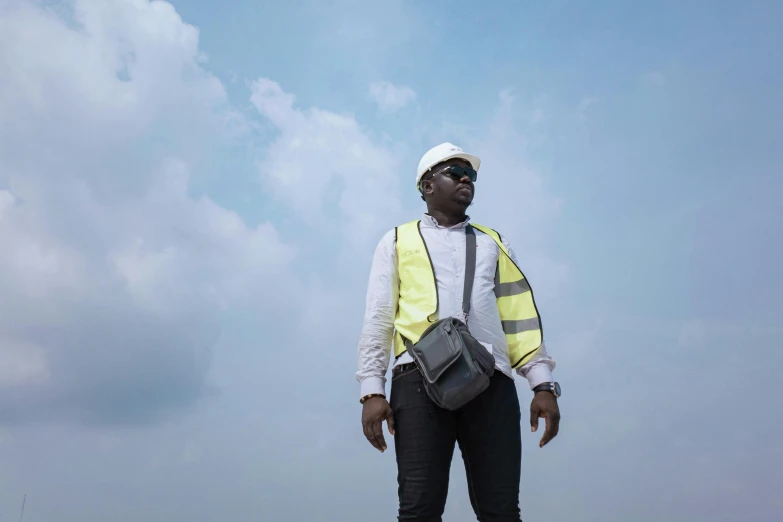 man in safety vest standing on top of a hill