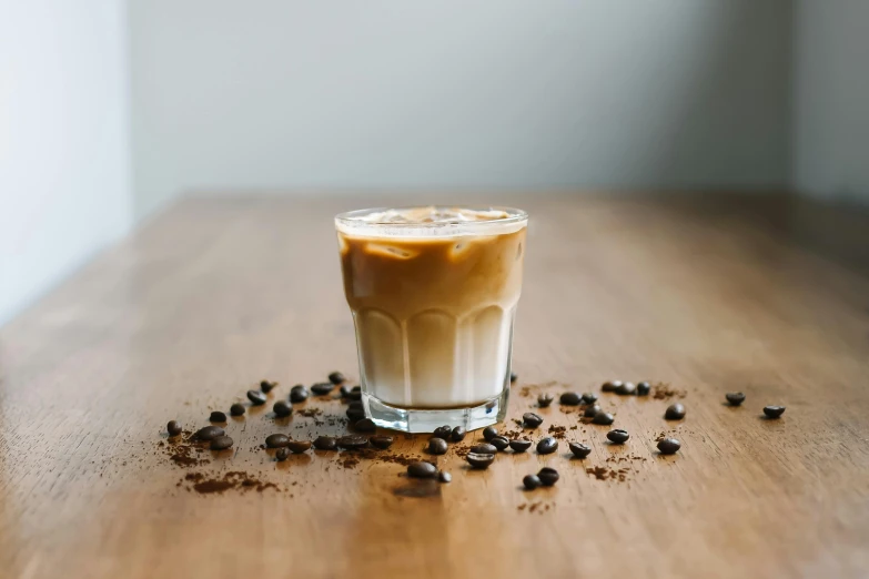 a small glass is filled with brown and white liquid