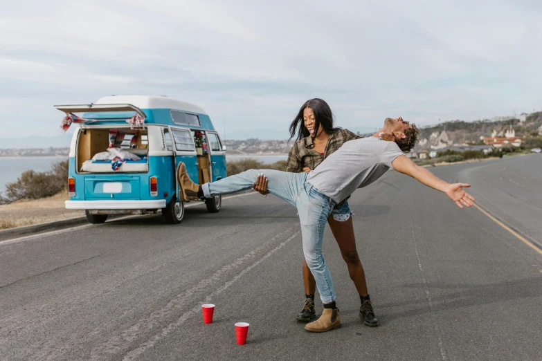 a woman hing a man in the street as he throws his leg over to grab them