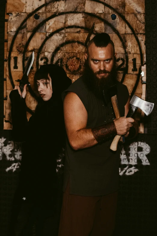 the man holds a large axe, standing next to two other people