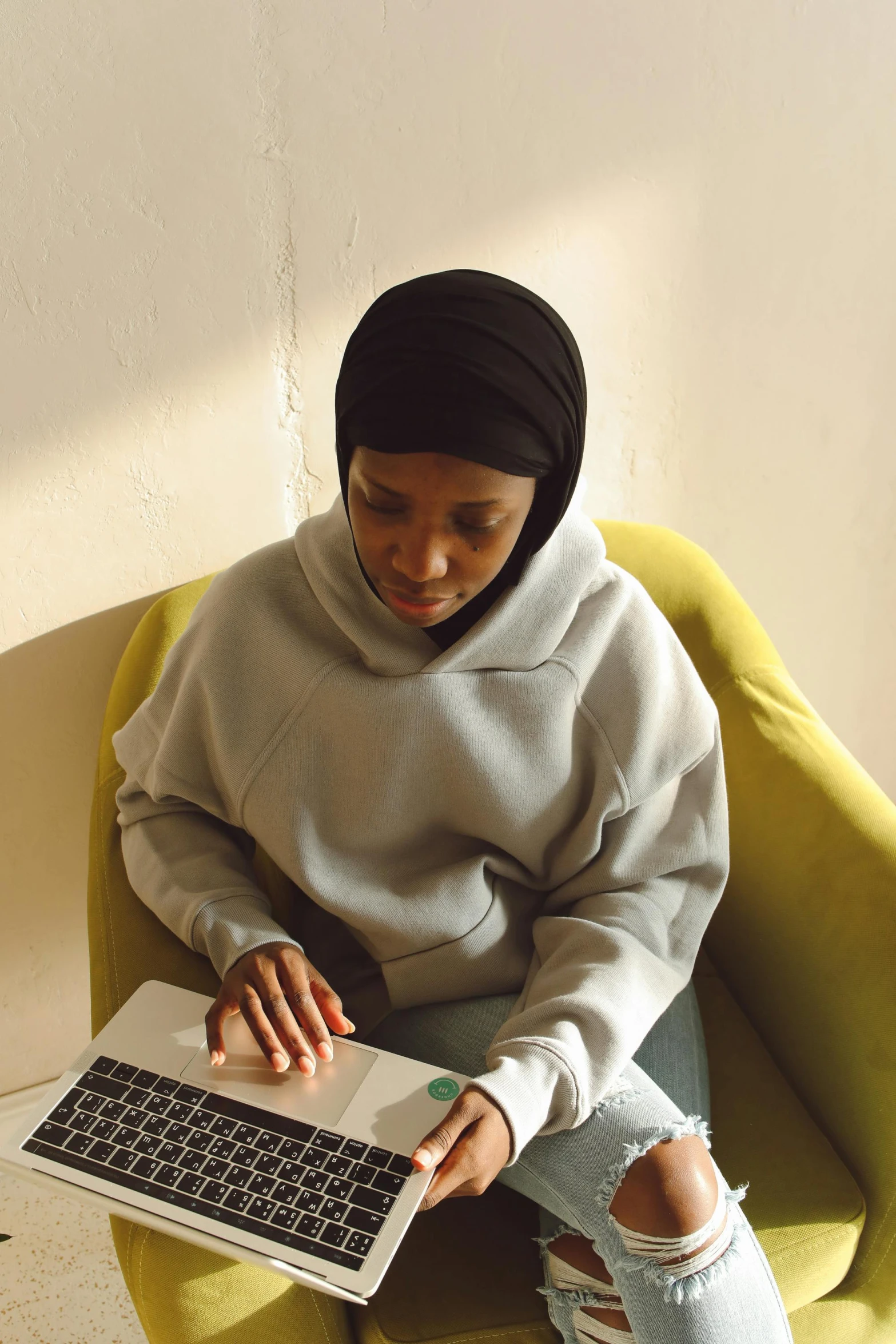 a woman sitting on a chair with a laptop