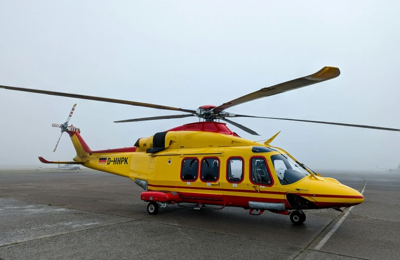 an orange and yellow helicopter on a concrete surface