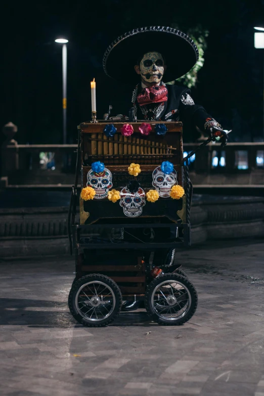 a skeleton dressed up on top of an old cart with a candle