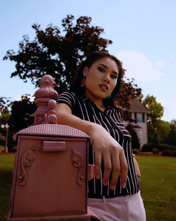 a woman in striped shirt holding a pink wooden box