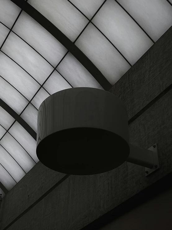 a round light fixture is lit up by a skylight