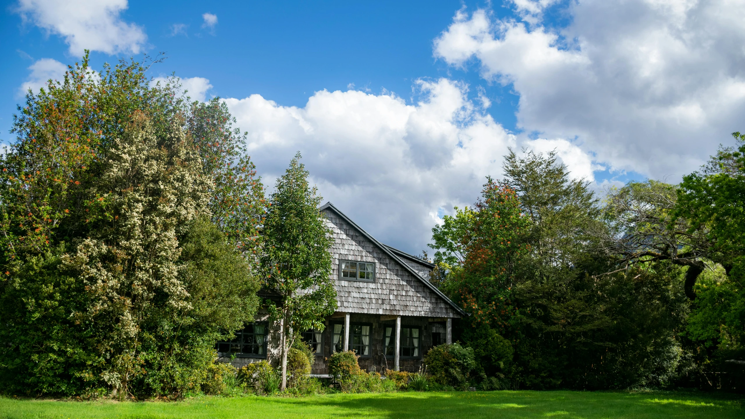 a house surrounded by trees and grass in the foreground