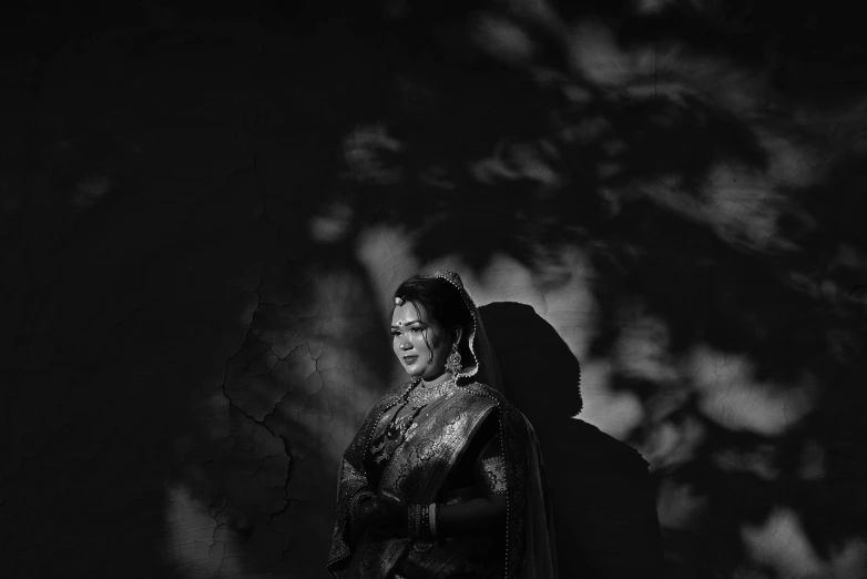 a woman stands near the tree shadows as she smiles