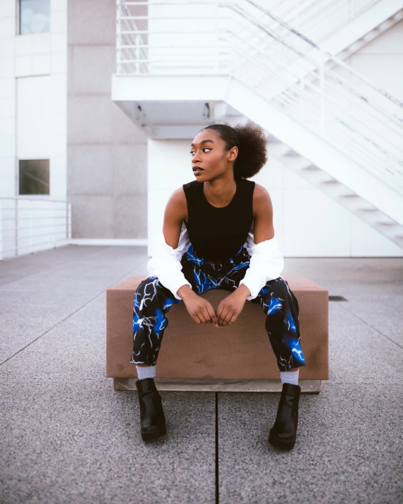 a black woman with an afro sitting on a cement bench