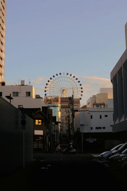 a ferris wheel sits atop a building on a city street