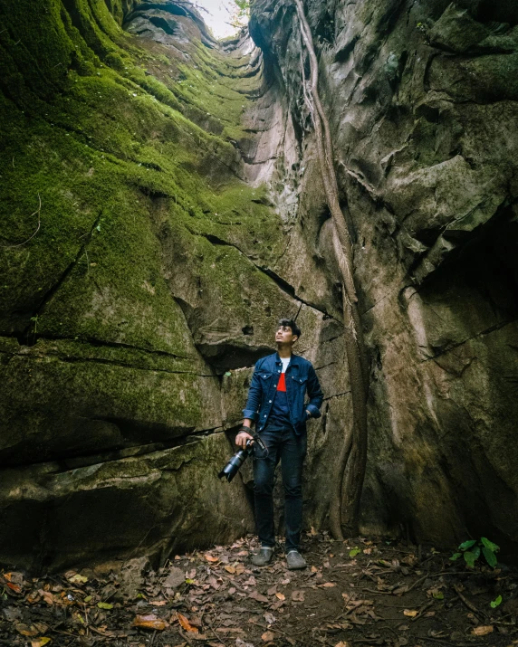 a man standing inside of a very tall cave