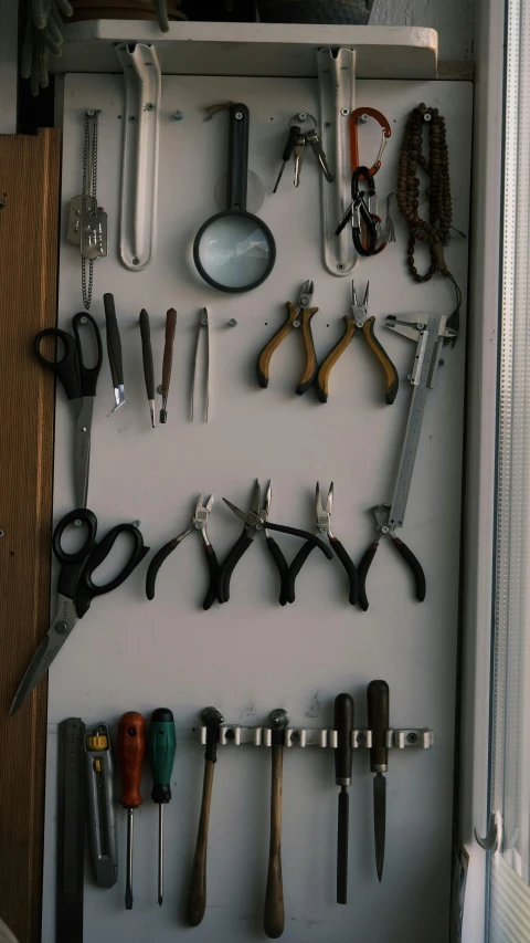 a wall that has some pairs of tools mounted to it