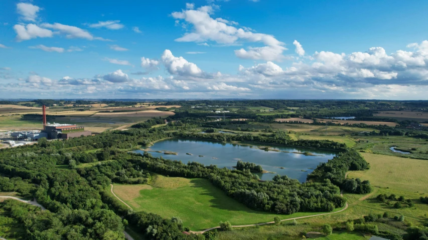 a field with many trees and water surrounded by fields