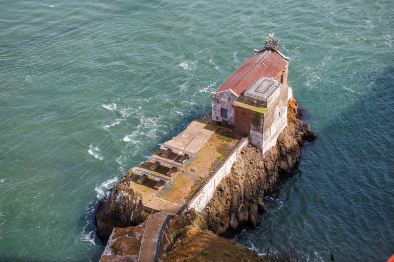 the lighthouse is near a rocky shore next to the water