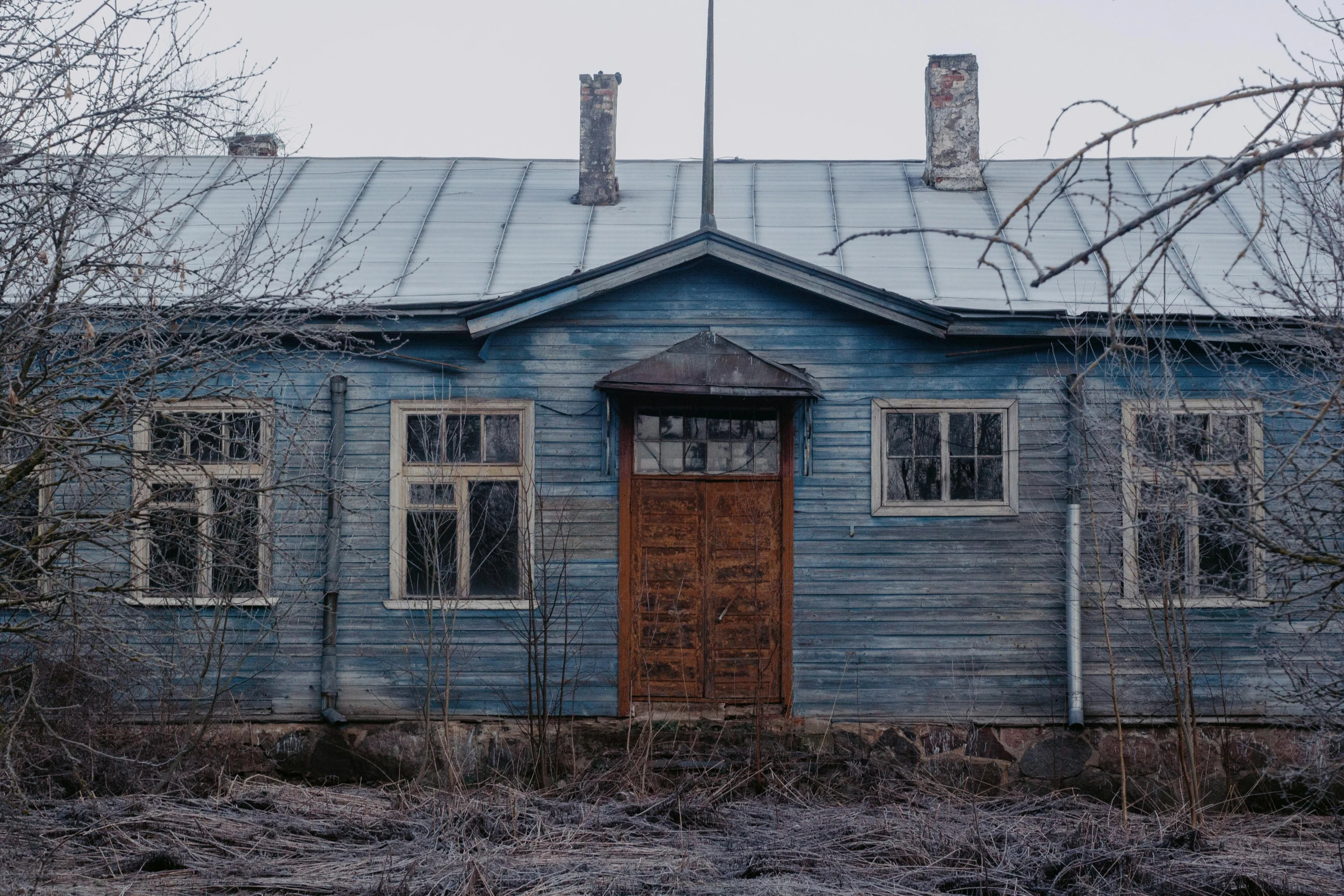 a small blue house with a brown door and two windows