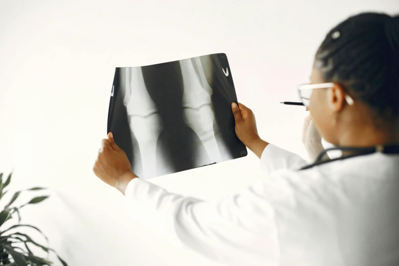 a woman in glasses looking at an x - ray