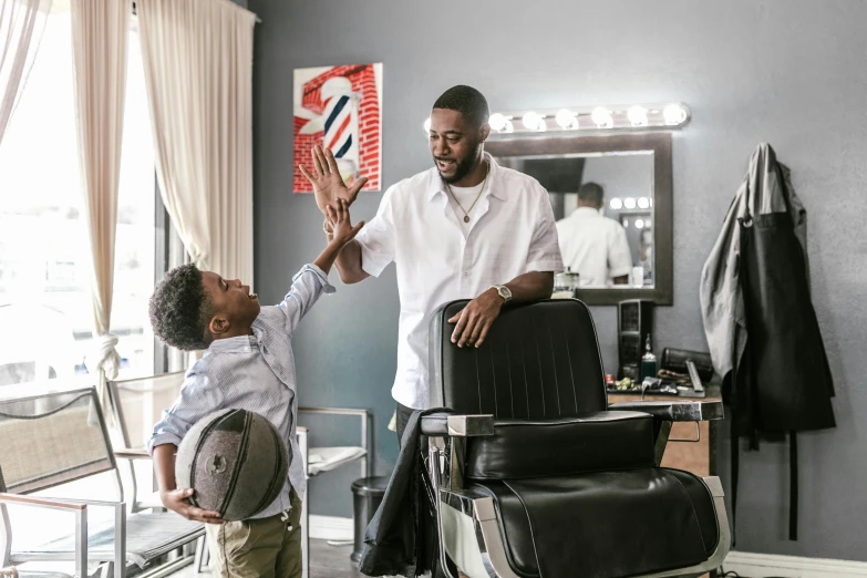 a boy standing next to an adult in a salon