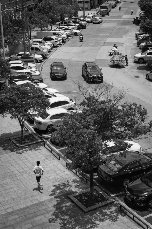 a person is standing on a sidewalk in a parking lot