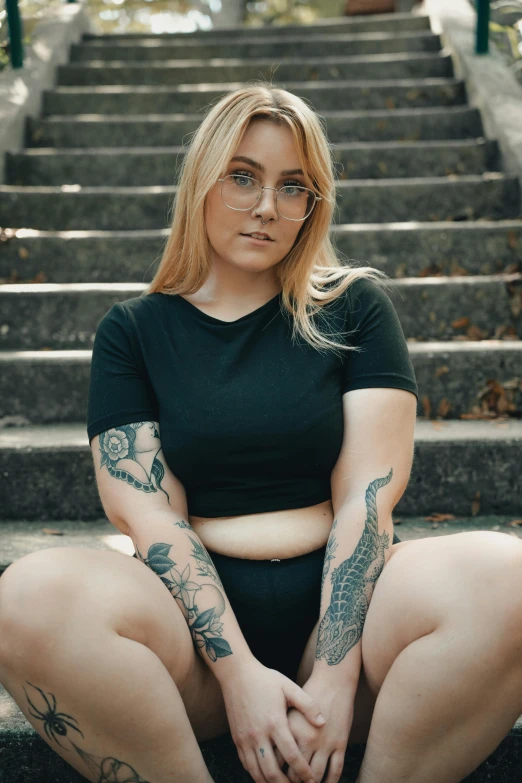 a girl with big  posing in front of some stairs